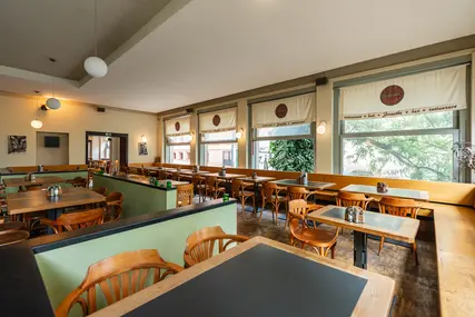 Stoly a sezení v hlavní části interiéru restaurace Zvonařka