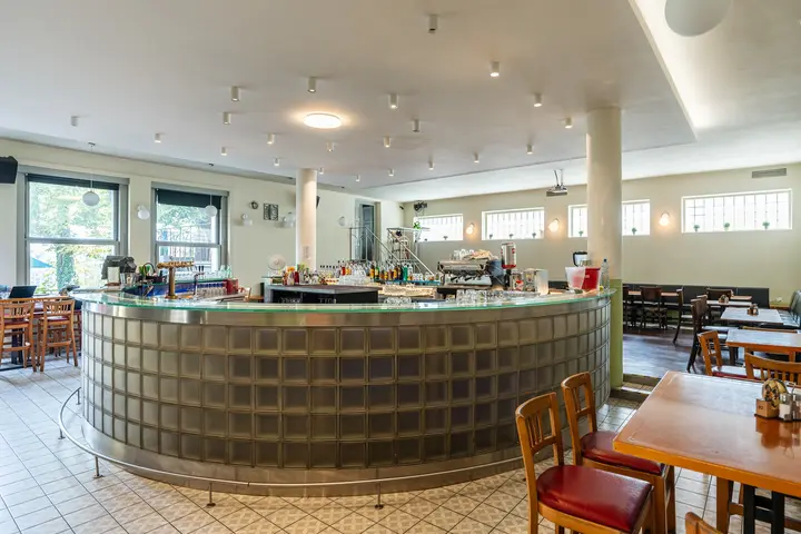 Útulný interiér restaurace Zvonařka s dřevěnými stoly a židlemi